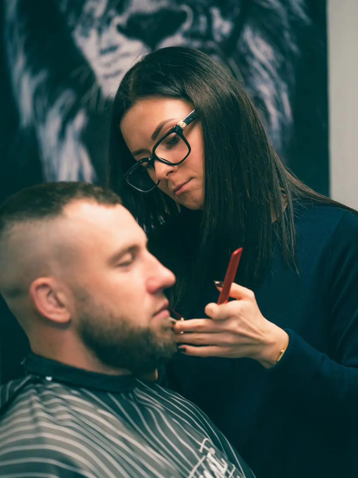 Meistare ar ķemmi koriģē klienta bārdu